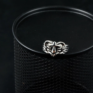 Gothic vintage stainless steel heart ring with cross and wing details on a black mesh