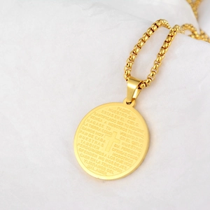 Collier en acier titane doré avec pendentif rond Padre Nuestro et croix sur fond blanc