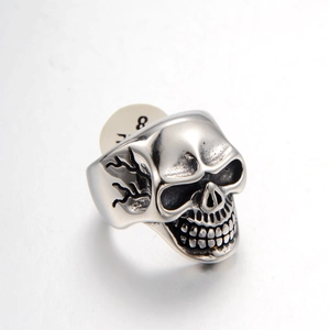 Macro shot of silver skull ring detail with intricate flame carving and size label