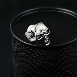 Detail of silver skull ring featuring vintage blackening and lightning patterns on the side