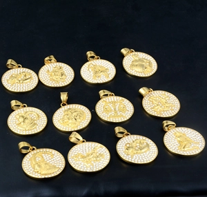 Présentation en matrice de 12 pendentifs zodiaque dorés avec des strass étincelants