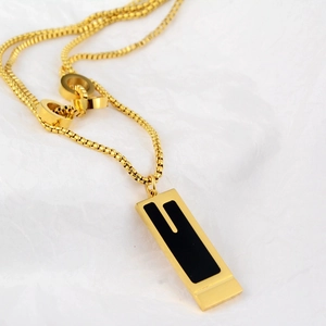Close-up of golden stainless steel box chain necklace with black rectangular pendant