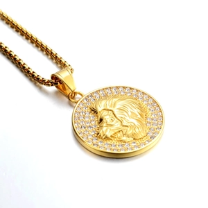 Détail du collier médaillon tête de lion doré avec incrustations de cristaux brillants