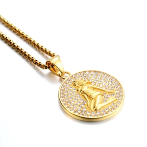 Détail du pendentif zodiaque plaqué or avec strass scintillants et relief gravé