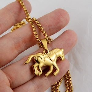 Detailopname van een gouden paardenhanger aan een titanium stalen boxketting voor heren en dames