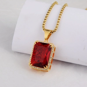 Detailed close-up of golden box chain necklace with a rectangular red ruby pendant and zircon