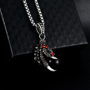 Detail of hip-hop dragon claw pendant with red crystals on black jewelry box