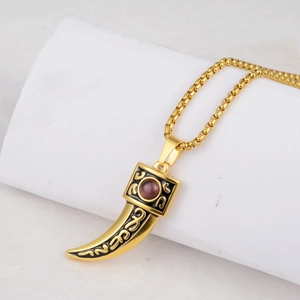 Detail of hip-hop wolf tooth pendant with red gemstone and black enamel on gold box chain