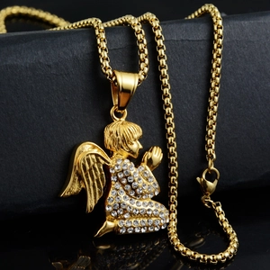 Macro shot of gold angel pendant with crystals on box chain over grey stone background