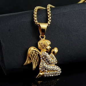 Macro detail of golden angel pendant with sparkling pavé stones on a black background
