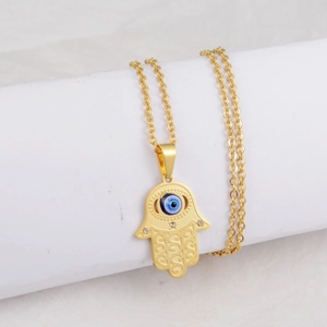 Close-up of golden Hamsa pendant with Evil Eye inlay and sparkling crystal details