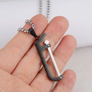 Detailansicht der Hand mit industriellem Sägeanhänger an einer Kugelkette in Silber