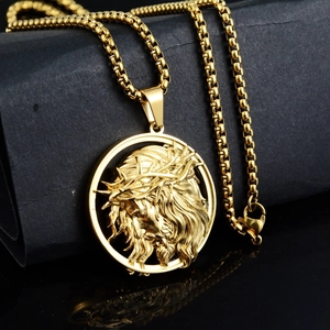 Détail du pendentif rond relief Jésus doré avec une chaîne à mailles carrées en acier