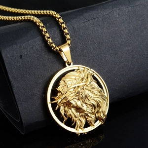 Détail macro du pendentif relief Jésus doré avec couronne d'épines sur base noire texturée