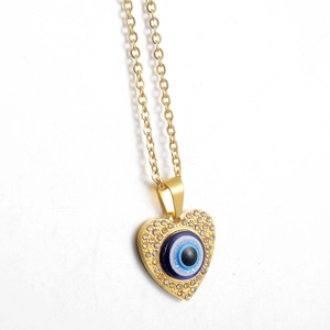 Detailed view of golden heart pendant featuring a blue evil eye and sparkling rhinestones