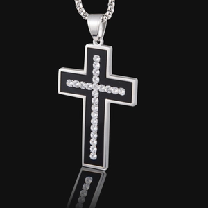 Collier avec pendentif croix en acier titane et diamants sur un fond noir élégant