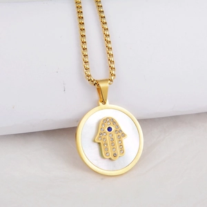 Close-up of golden Hamsa Hand pendant with blue stone and white shell inlay on necklace