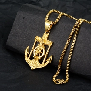 Detailed close-up of a gold anchor cross pendant with Jesus on a classic box chain