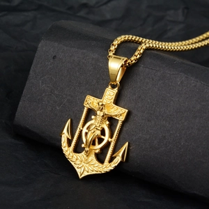 Classic gold anchor crucifix pendant with box chain on a dark textured background
