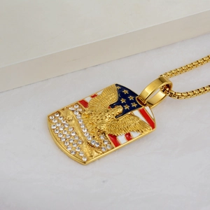 Detailed close-up of golden eagle pendant with US flag enamel and box chain necklace