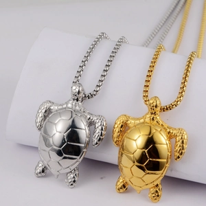 Close-up of gold and silver sea turtle pendants with geometric shell engraving details