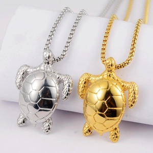 Detailed close-up of gold and silver sea turtle pendants on box chains displayed on pillars