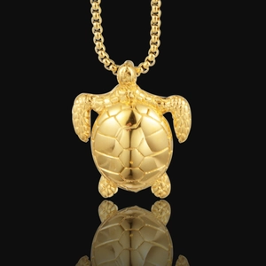Polished gold sea turtle pendant necklace with geometric shell texture on a box chain