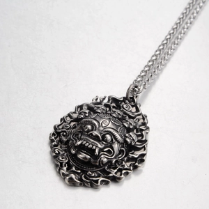 Detail of vintage gothic lion head pendant with skull accents and silver finish