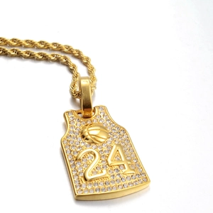 Vista macro de un collar colgante de camiseta bañada en oro con diamantes y número 24