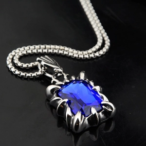 Vue macro du pendentif griffe de dragon hip hop avec pierre saphir bleu foncé