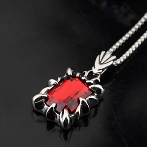 Vue détaillée de la pierre rouge sertie par des griffes de dragon sur pendentif hip hop