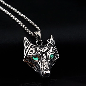 Makroaufnahme von Wikinger-Wolfskopf-Anhänger mit grünen Kristalaugen und Metallkette