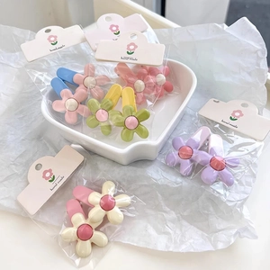 Close-up of colorful floral hair clips in pastel shades with hand made packaging cards