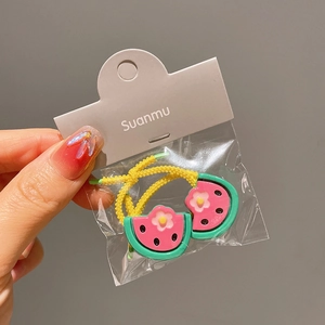 Close-up of cute watermelon resin charms on yellow elastic hair ties for girls