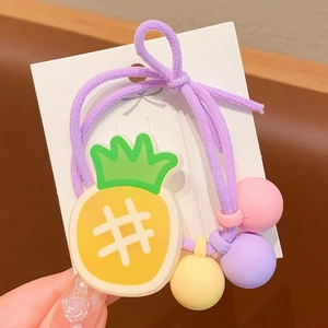Détail d'un élastique à cheveux violet avec breloque ananas et perles colorées