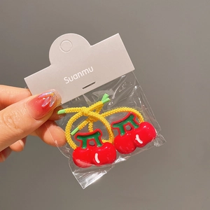 Detail shot of cute red cherry elastic hair bands in clear retail packaging with yellow ropes