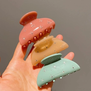 Three-piece acetate hair claw set in pink, amber, and mint green with star rhinestones