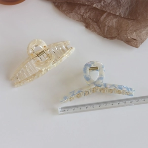 Detailed close-up of large marble texture hair claw clips with strong metal spring