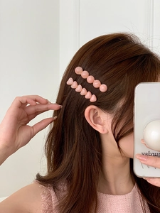 Detail of pink jelly texture heart and bead hair clips worn on brown long hair