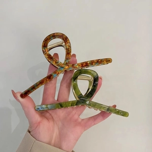 Large acetate hair claws in tortoiseshell and marble green finish for elegant styling