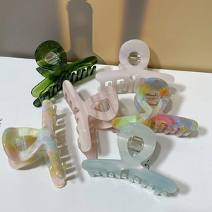 Detail view of colorful medium hair claw clips in various acetate marble patterns