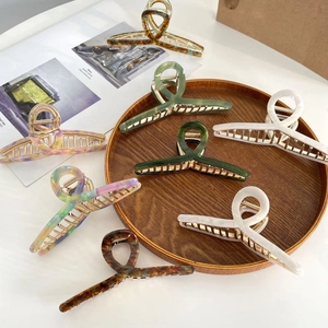 Chic acetate hair claw clips in marble and tortoise shell patterns with gold metal hinges