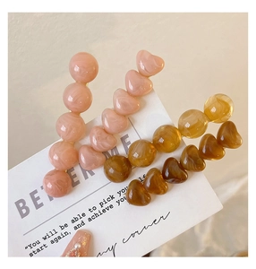 Detailed view of resin heart and round bead hair clips with elegant marble textures