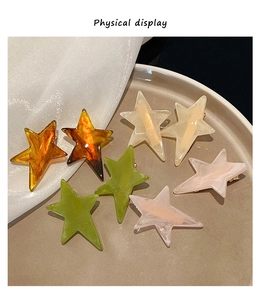 Detailed physical display of star hair clips in acetate texture on elegant ceramic tray