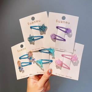 Détail de barrettes à cheveux colorées avec étoiles pailletées et motifs sirène