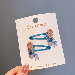 Détail de barrettes sirène bleu scintillant avec décorations en résine pour fillettes