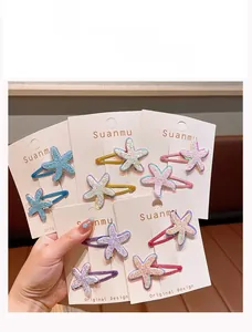 Detailed close-up of glitter starfish hair clips in multiple colors on white display cards