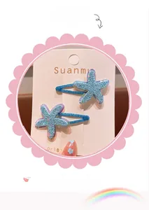 Detail of blue glitter starfish hair clips set on pink decorative display card