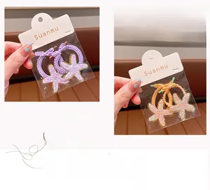 Detail showing purple and orange wavy hair ties with sparkling starfish ornaments on a card