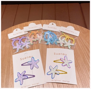 Detail of colorful sequined starfish hair clips and elastics on a wooden table